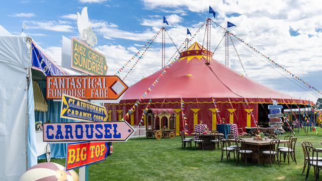 Enter the big top circus tent on a sunny day company celebration.