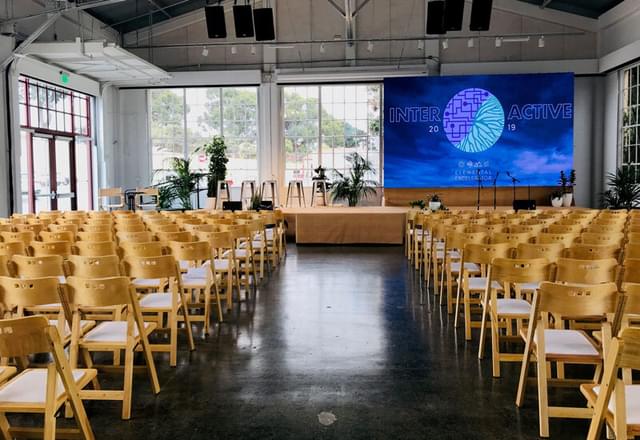 Rows of chairs set up for a conference in an event space at Fort Mason, San Francisco.