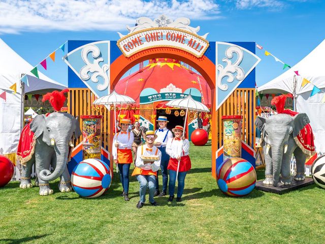 Carnival event entrance with employees smiling.