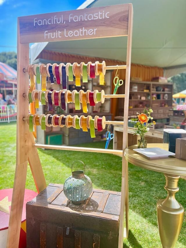 Display of self-serve fruit leather like ribbons on rolls.