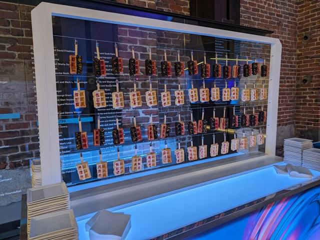 Waffles on sticks hanging on a wire display.