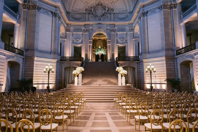 Inside of San Francisco City Hall with rows of chairs set up for a wedding ceremony.