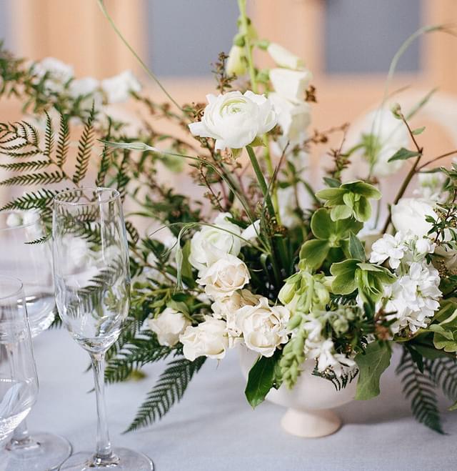 Flower arrangement with white blossomed flowers in a white vase.